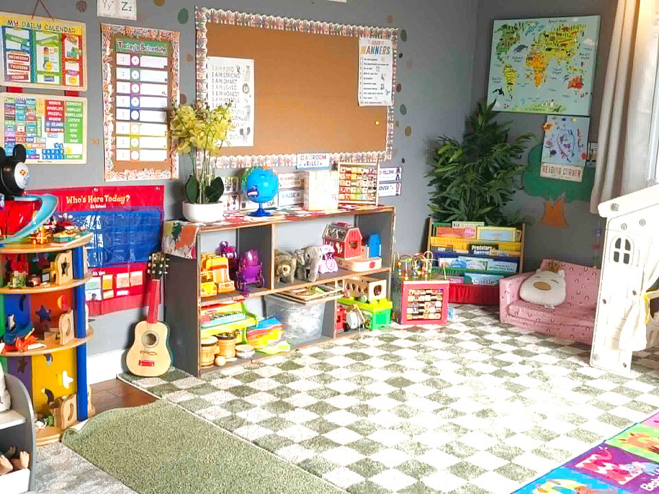 Learning corner with daily calendar, manners chart, world map, and shelves of toys, books, and instruments